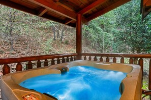 Relax in a secluded hot tub surrounded by a natural forest setting.