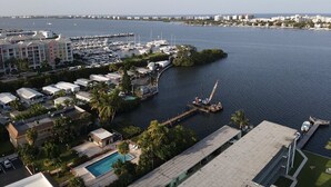 Un puerto deportivo con barcos, un muelle y un edificio con piscina.