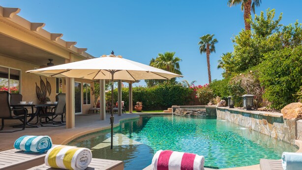 A pool area with lounge chairs, a pergola, and a view of the pool. - 5 min to Coachella - Boho Chic Oasis with Pool & Spa (Indio)