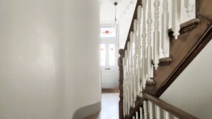 A hallway with a wooden staircase and white balusters. - Spacious family townhouse, Telegraph Hill, Summer '23 (London)