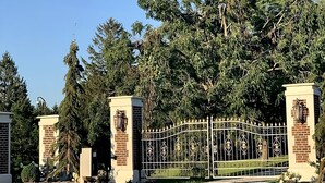 A gated entrance with a metal fence and brick pillars, surrounded by trees and a clear sky. - THE LOFT an UPSCALE RUSTIC 2 Bedroom 2 Washroom Private Guest House on 16acres. (Tottenham)