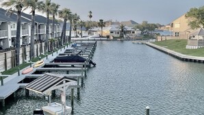 Un port esportiu amb vaixells amarrats, un canal navegable i una filera d'edificis amb balcons.
