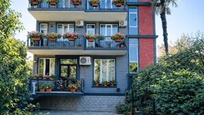 Un edificio de varios pisos con balcones y plantas en macetas.