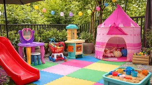 Zona de juegos infantiles con tobogán, casita y diversos juguetes.