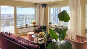 Un salon moderne avec une grande fenêtre, un canapé, une table basse et un téléviseur.