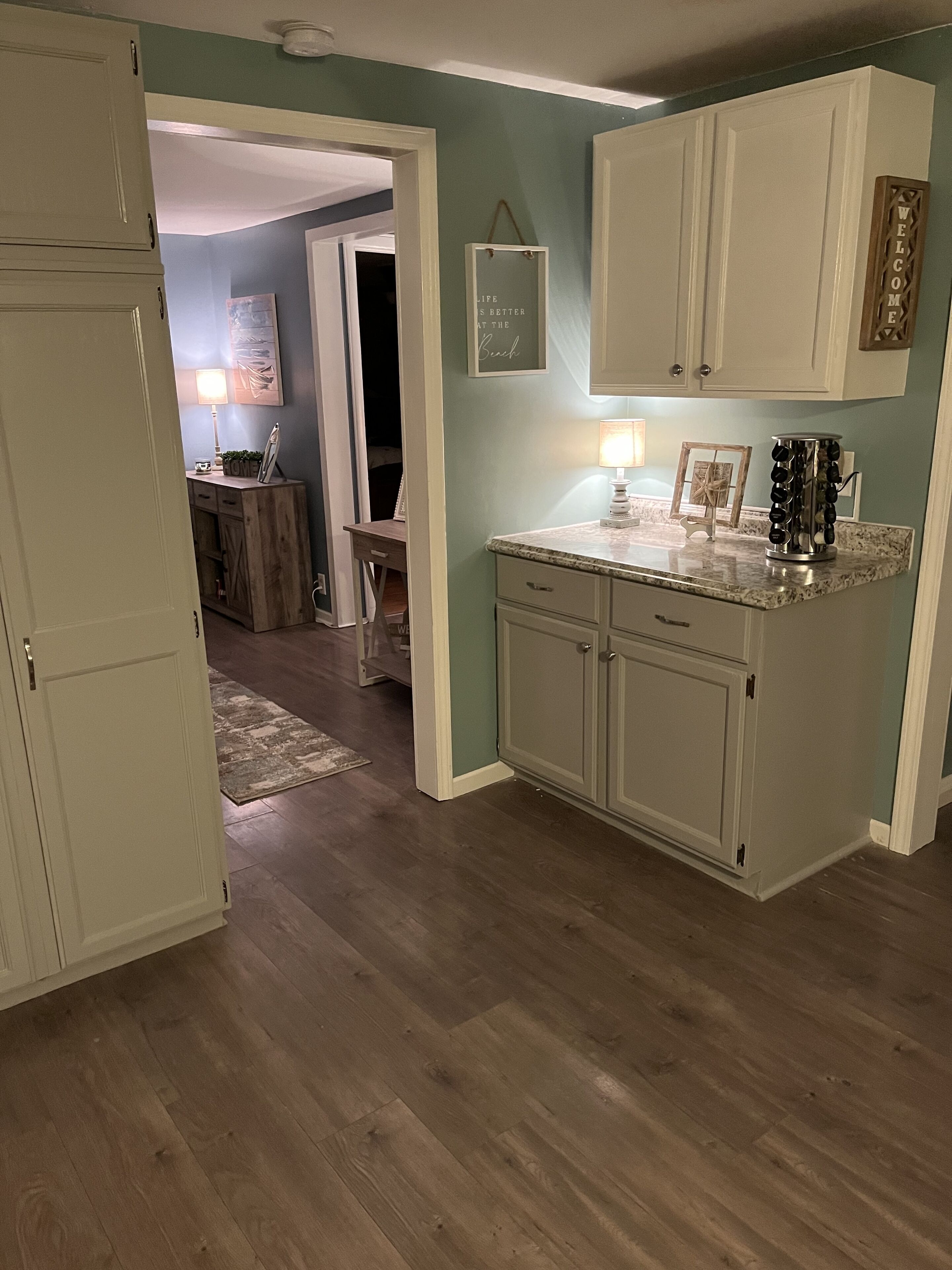 A kitchen with wooden cabinets, a countertop, and a hanging sign.