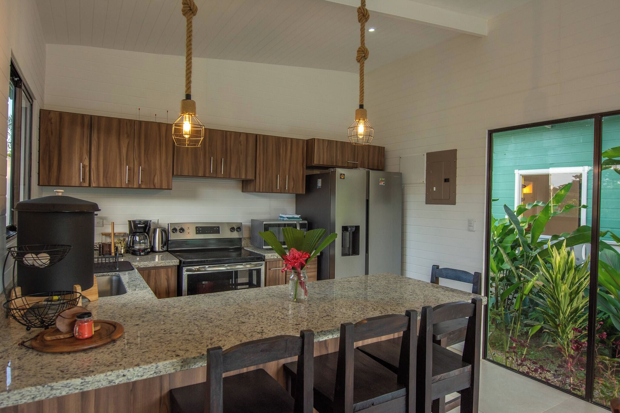 A modern kitchen with wooden cabinets, stainless steel appliances, and a granite countertop.