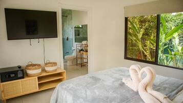 Una camera da letto con un letto, una TV, un armadietto in legno e una finestra vista verde.
