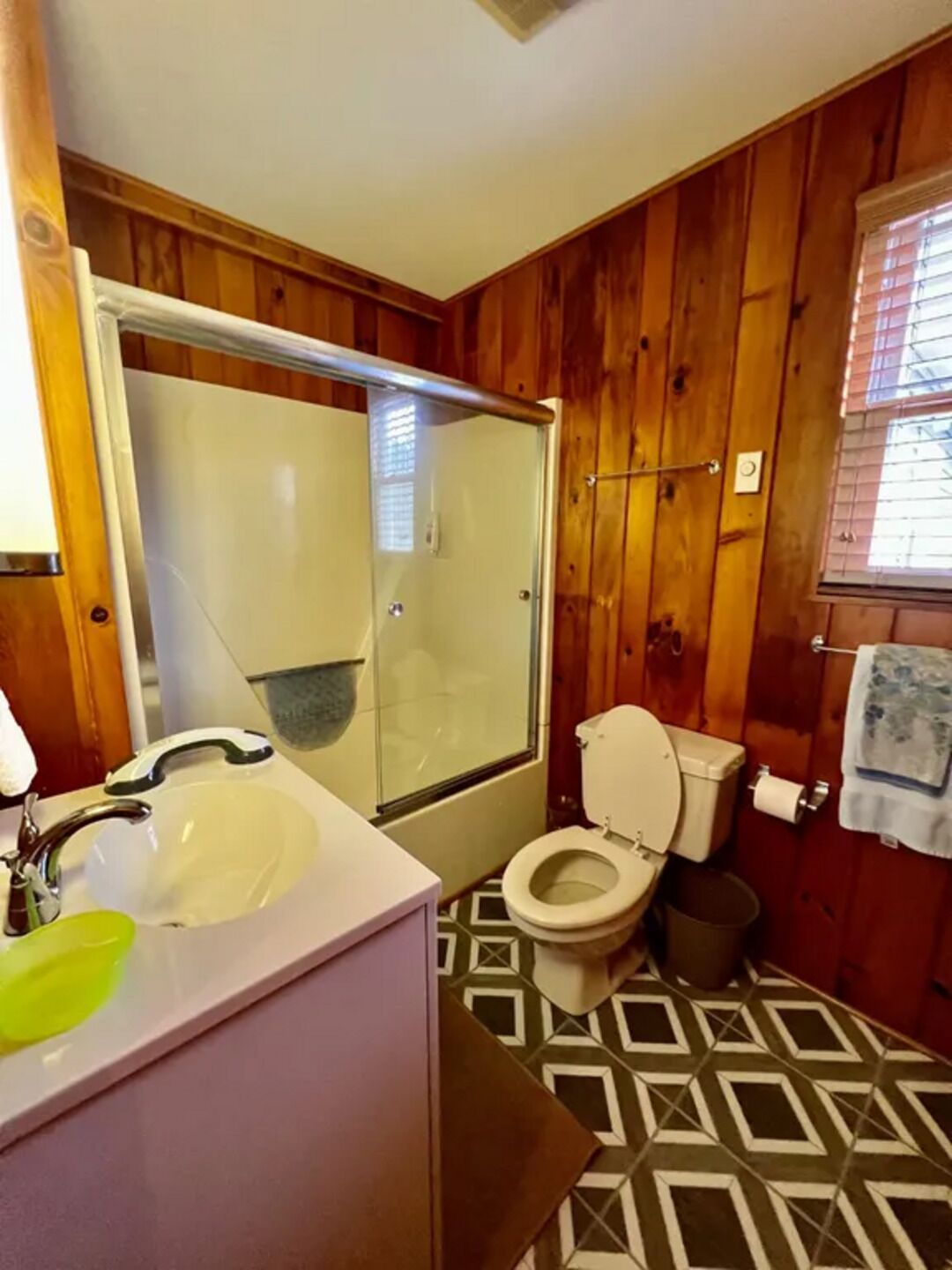Een badkamer met een douche, toilet en wastafel.