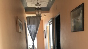 A hallway with a tiled floor, a hanging light fixture, and a door leading to another room. - T4 100m2 beach 250m Six fours (Six-Fours-les-Plages)