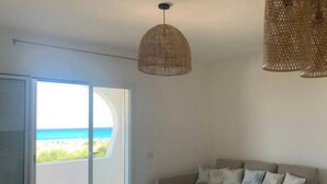 A room with a large sliding glass door leading to a balcony with a view of the beach. - Simius beach - [Free Parking] (Simius)