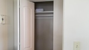 A room with a closed door, a closet with hanging space, and a light switch on the wall. - Sheepscot Harbour Studio #215 (Edgecomb)