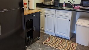 A compact kitchen with a refrigerator, microwave, toaster, and a small cabinet. - Waterfront king studio with kitchen Sheepscot Harbour Studio #205 (Edgecomb)