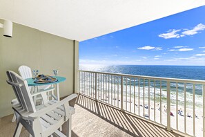 Ein Balkon mit Blick auf Strand und Meer.