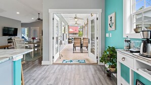 Eine moderne Küche mit Essbereich, einem Fernseher und einem Deckenventilator.