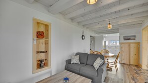 Una sala de estar con un sofá gris, una mesa de madera y un mueble de madera con estantes.