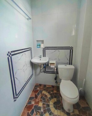 A bathroom with a tiled floor, a sink, and a toilet. - ZM Residence (Dapa)
