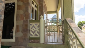 A stone building with a gated entrance, a staircase, and a view of a mountain. - Topaz Apartment Villa - Piton View  (Soufrière)