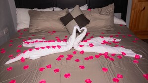 A bed with rose petals and towels arranged in a heart shape. - Topaz Apartment Villa - Piton View  (Soufrière)