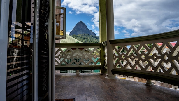A balcony with a view of a mountain, wooden flooring, and a lattice railing. - Topaz Apartment Villa - Piton View  (Soufrière)