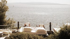 A person relaxing on a bed with a view of the sea. - Luxury Beachfront Villa With Pool for two Families (Okrug)