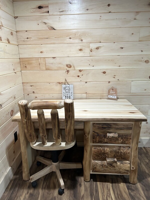 Un escritorio de madera con una silla, un letrero que dice 'Sé la mejor versión de ti mismo' y otro letrero que dice 'El amor construye un hogar feliz'.