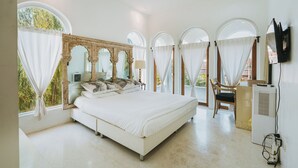 A spacious bedroom with a large bed, multiple windows with curtains, a TV, and a heater. - Arpo Pool Villa Riverside Bangkok | 3-Bedroom Private Villa Near MRT & Iconsiam (Bangkok)