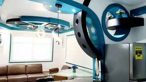 A modern kitchen with a stainless steel refrigerator, a glass dining table, and a brown leather sofa. - (RH)⭕️Los angeles (#1) front of airport (Carolina)