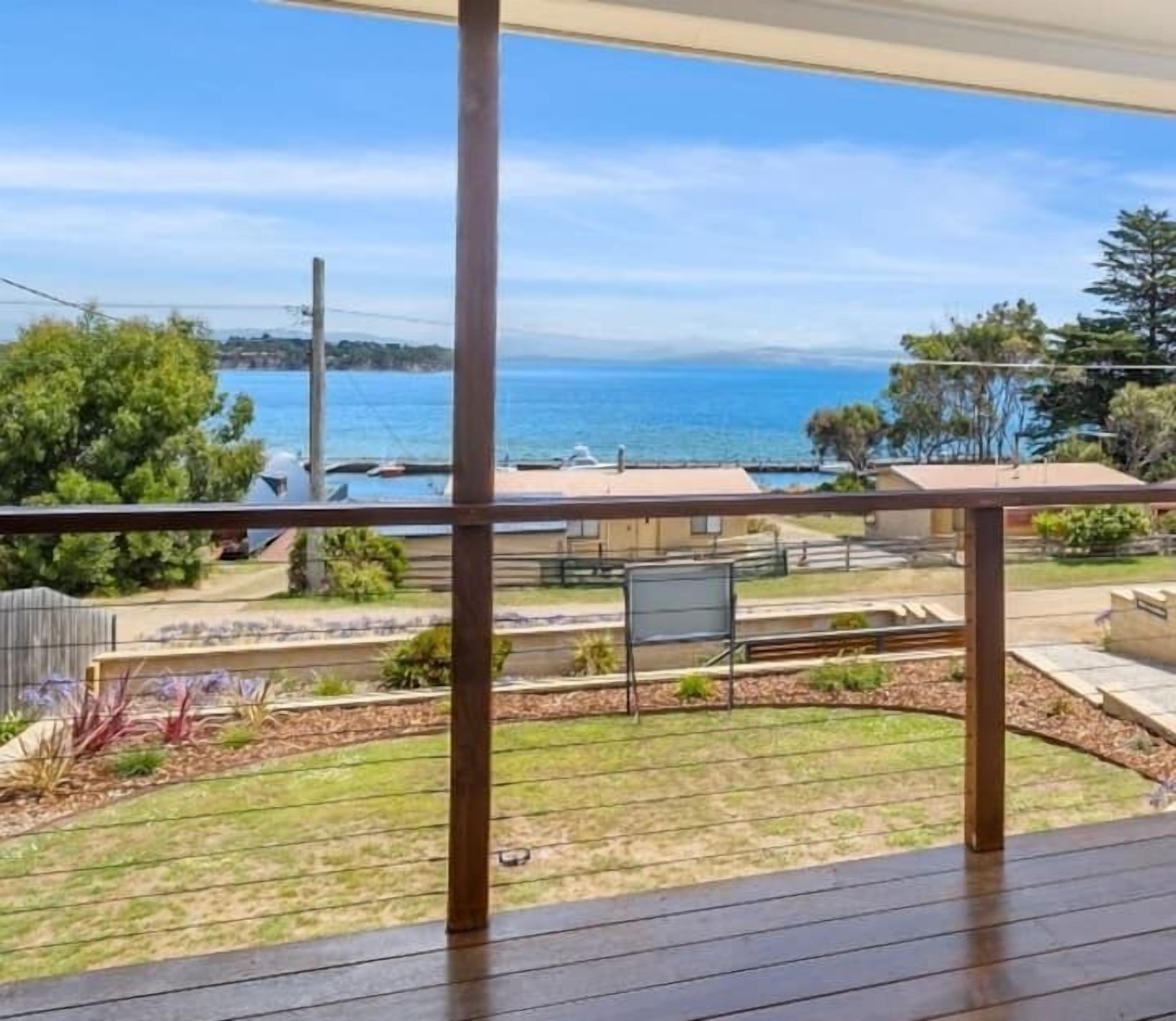 Varanda com vista para o mar e um jardim.