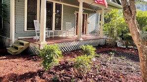 A house with a porch, steps, and a flag.