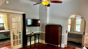 A living room with a ceiling fan, a television, a wooden cabinet, a sofa, and a coffee table.