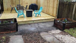A wooden deck with outdoor furniture and raised garden beds.