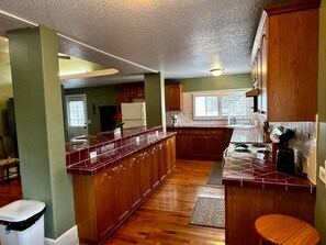 A spacious kitchen with wooden cabinets, a central island, and a built-in stove.