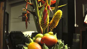 A fruit bowl with bananas, apples, and a decorative plant.