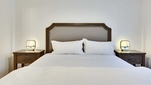 A neatly made bed with white linens, flanked by two bedside tables with illuminated mirrors and drawers. - Pool & Gameroom, pet friendly, 10 Minutes from South congress, 20 from Downtown (Austin)