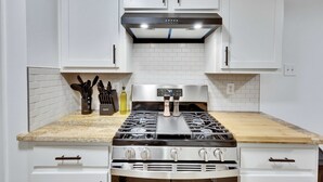 A kitchen with white cabinets, a stainless steel stove, and a wooden countertop. - Pool & Gameroom, pet friendly, 10 Minutes from South congress, 20 from Downtown (Austin)