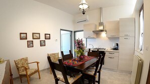 Ein Essbereich mit einem Holztisch und Stühlen, einer Vase mit Blumen und gerahmten Bildern an der Wand.