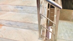A staircase with a metal handrail and a vent on the wall. - Comfort Inn Hotel.Near MayurVihar Metro1 (New Delhi)