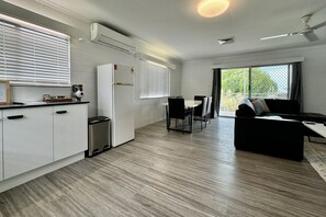 Enjoy a compact yet functional space with a kitchenette, dining area, and living space featuring a sofa and coffee table.