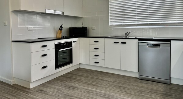 Enjoy cooking in this well-equipped kitchen with an oven, stainless steel appliances, and ample counter space.