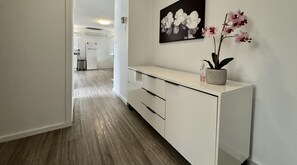 Stylish hallway with a console table, potted orchid, and framed artwork.