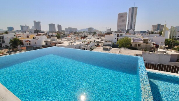 A rooftop swimming pool with a cityscape view.