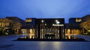 A modern building with a sign reading "Pine Beach" at twilight. - Pine Beach Golf Hotel (Haenam)