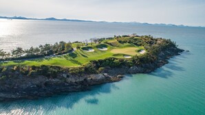 An aerial view of a golf course with bunkers and a water body. - Pine Beach Golf Hotel (Haenam)