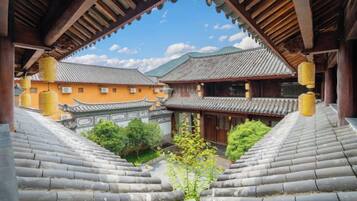A traditional building with a tiled roof, wooden beams, and a courtyard with steps leading to the entrance.