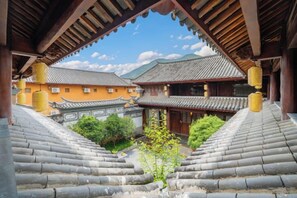 A traditional building with a tiled roof, wooden beams, and a courtyard with steps leading to the entrance. - Jianyang Inn (Jianchuan)