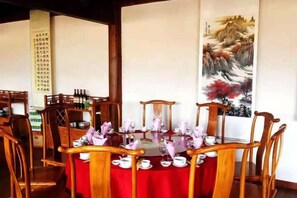 A traditional dining setting with a round table, chairs, and a red tablecloth. - Jianyang Inn (Jianchuan)