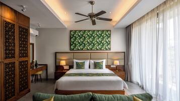 A hotel room with a large bed, a ceiling fan, a desk, and a view of the outdoors.