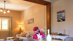 Ein gemütliches Wohnzimmer mit einem Holzesstisch, einer Couch und einer Lampe.