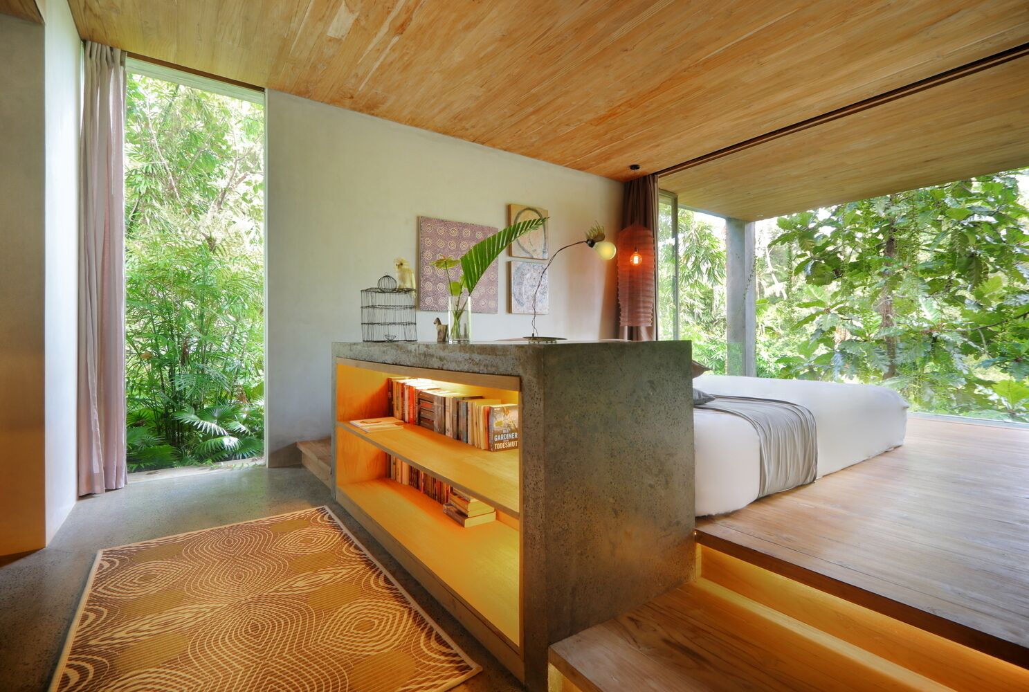A modern bedroom with a large window, a wooden ceiling, and a built-in bookshelf.